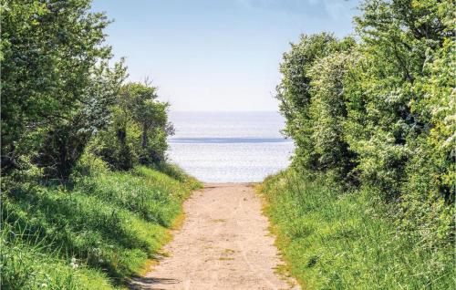 a dirt road leading to the ocean with trees at 1 Bedroom Cozy Apartment In Vasteville in Vasteville