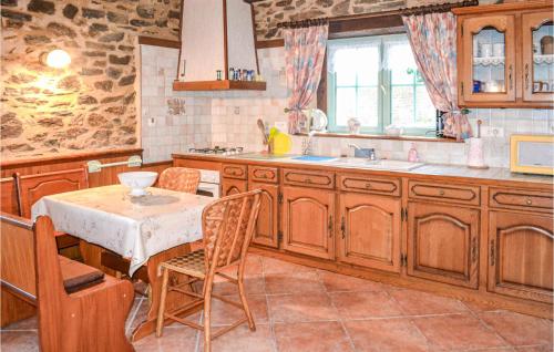 a kitchen with wooden cabinets and a table and a sink at Stunning Home In Payzac With 3 Bedrooms, Private Swimming Pool And Outdoor Swimming Pool in Payzac