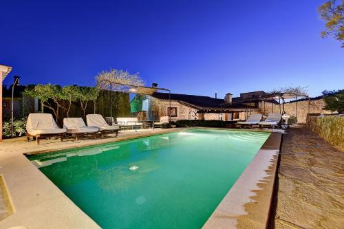 a swimming pool with chairs and a house at Villa Can Pulit by Slow Villas in El Port de la Selva