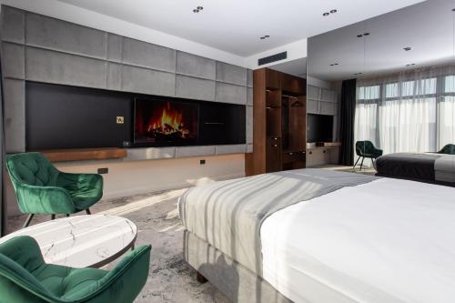 a bedroom with a large bed and a fireplace at Vila Avy in Haţeg