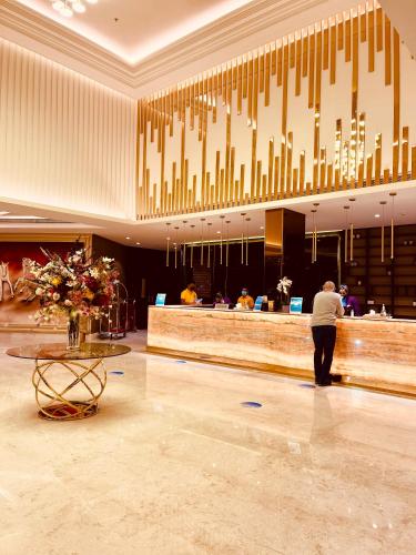 a man standing at a bar in a hotel lobby at JUFFAIR BOULEVARD HOTEL & SUITES in Juffair