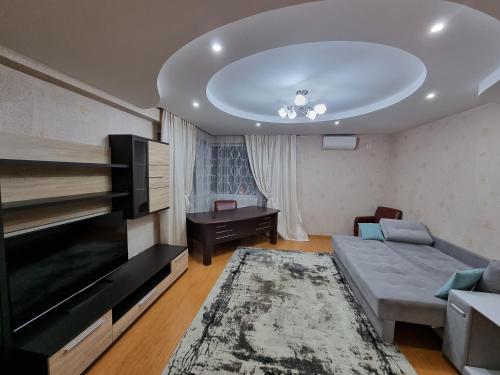 a living room with a couch and a tv at Rent Grand Delux Apartments Design in Chisinau in Chişinău