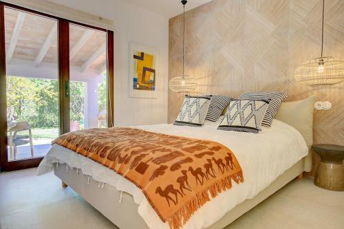 sypialnia z dużym łóżkiem z poduszkami w obiekcie Villa Roca Verde by Slow Villas w mieście Puigpunyent