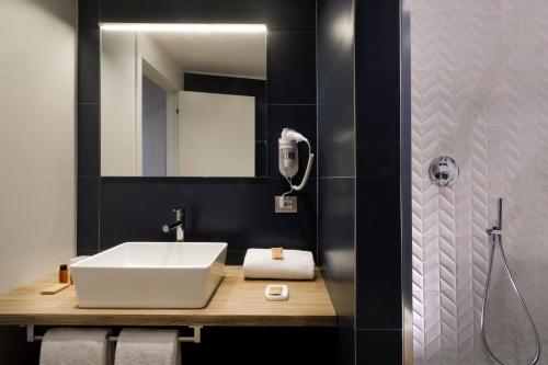 a bathroom with a sink and a mirror at Hotel Baylle in Cagliari