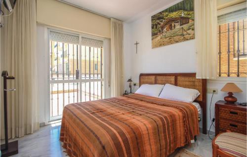ミハス・コスタにある2 Bedroom Beautiful Apartment In Mijas Costaのベッドルーム1室(オレンジ色の毛布、窓付)