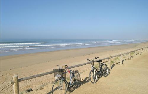 deux vélos garés à côté d'une clôture sur une plage dans l'établissement Nice Apartment In St, Hilaire De Riez, à Saint-Jean-de-Monts