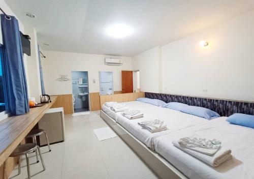 a room with two beds with towels on them at กู๊ดวิวสัตหีบ in Sattahip