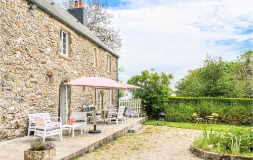 un patio avec une table, des chaises et un parasol dans l'établissement Gorgeous Home In Bricquebec-En-Cotentin, à Saint-Martin-le-Hébert