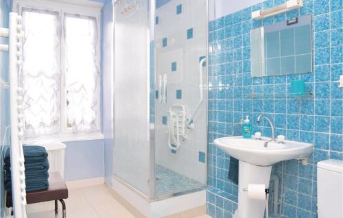 a blue tiled bathroom with a sink and a shower at 2 Bedroom Cozy Home In Le Beny Bocage in Le Bény-Bocage