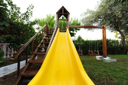 a yellow slide in a yard with a staircase at Golden Lighthouse Hotel in Patara