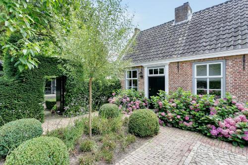 a brick house with a garden of flowers at Van Gogh Cottage in Nuenen