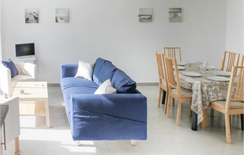 un salon avec un canapé bleu et une table dans l'établissement Beautiful Home In Erdeven With Wifi, à Erdeven