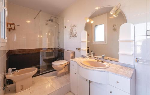 uma casa de banho com um lavatório, um WC e um espelho. em Amazing Home In Lametlla De Mar With Swimming Pool em Les tres Cales