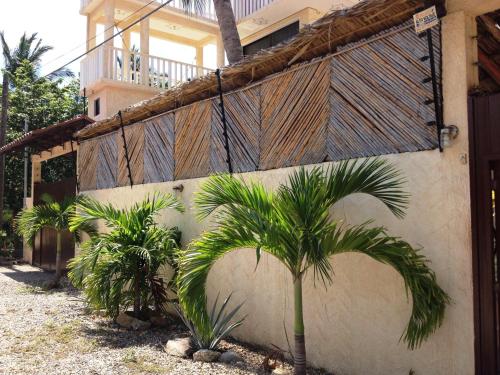 a house with palm trees in front of a building at QUINTA DIAMANTE villas&hotel in Barra Vieja