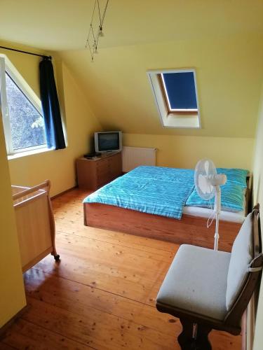 a bedroom with a bed and a chair in it at Casa Napsugár Panzió in Apostag