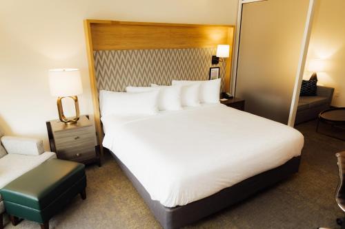 ホプキンスビルにあるHoliday Inn & Suites - Hopkinsville - Convention Ctr, an IHG Hotelの大きなベッドとソファが備わるホテルルームです。