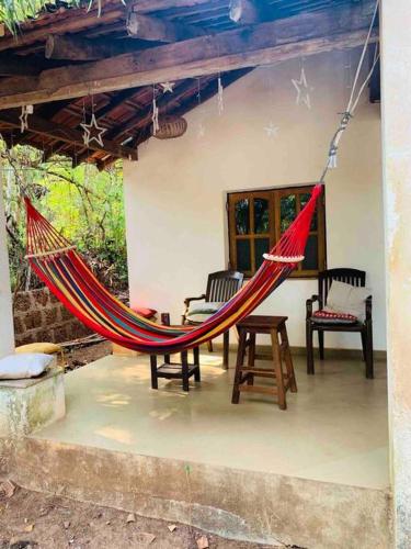 a red hammock hanging from a porch of a house at The Sunset Chalet in Anjuna