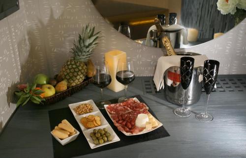 a table with two glasses of wine and a tray of food at Hotel Tiro a Volo in Pozzuoli