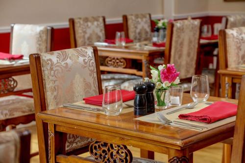 a wooden table with red napkins and glasses on it at Best Western Henbury Lodge Hotel in Bristol