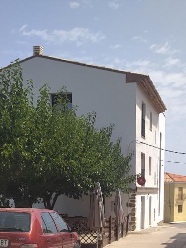 a red car parked in front of a white building at Cal Mistero in Useras