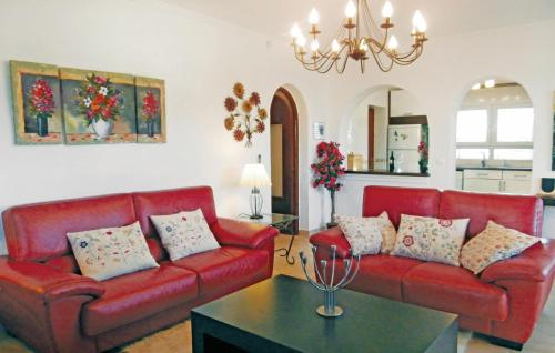 una sala de estar con 2 sofás rojos y una mesa. en Awesome Home In Orihuela Costa With 4 Bedrooms, Wifi And Outdoor Swimming Pool en Playas de Orihuela