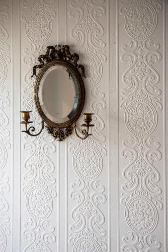 a mirror on a wall with a white wall at La Maison Ruffinoise in Sainte-Ruffine