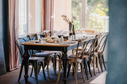a dining room table with chairs and wine glasses at Sure Hotel by Best Western Châteauroux in Le Poinçonnet