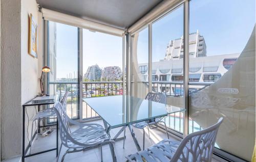 a balcony with a glass table and chairs at Lovely Apartment In La Grande-Motte in La Grande-Motte
