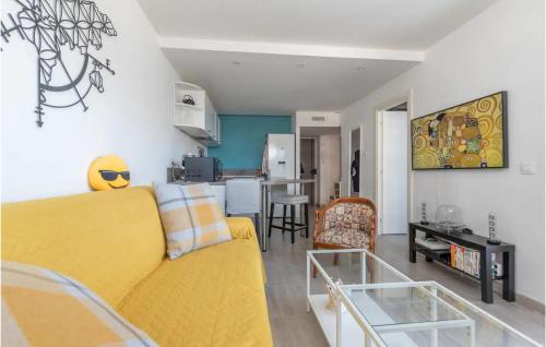 a living room with a yellow couch and a kitchen at Lovely Apartment In La Grande-Motte in La Grande-Motte