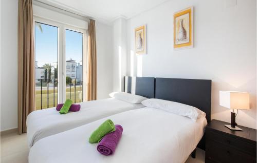 1 dormitorio con 2 camas con almohadas moradas y verdes en Lovely Apartment In Roldn With Outdoor Swimming Pool, en Los Tomases