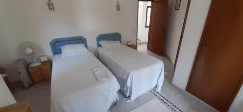 Quinta Da Mimosa في مونشيك: غرفة نوم بسريرين وباب لغرفة