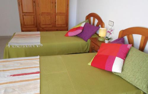 two beds with colorful pillows on them in a room at Awesome Apartment In Blanes With Kitchen in Blanes