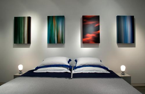 a bedroom with a bed with four paintings on the wall at Art Gallery Apartment in Lisbon