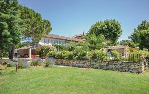 a house with a stone wall and a yard at Mas Melusine in Caderousse