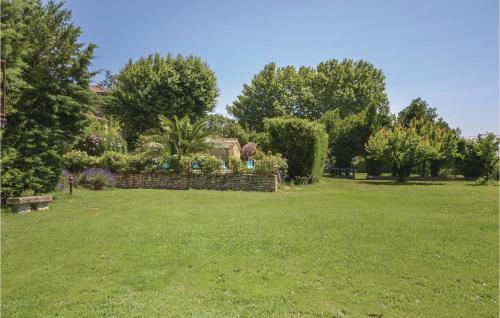 a garden with a stone fence and trees at Mas Melusine in Caderousse
