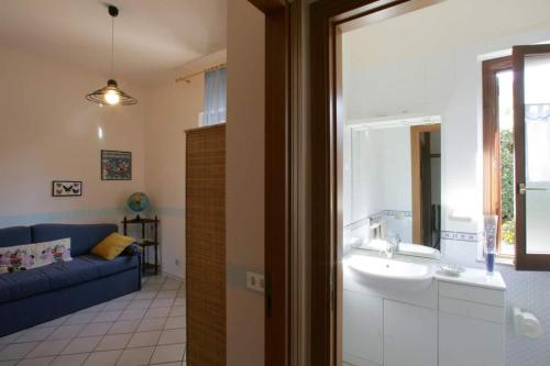 a bathroom with a sink and a blue couch at Villa Levante vista mare Cornino in Custonaci