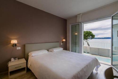 a bedroom with a large bed and a large window at Hotel Saviola in Sirmione