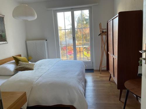 a bedroom with a bed and a large window at au jardin in Zuchwil