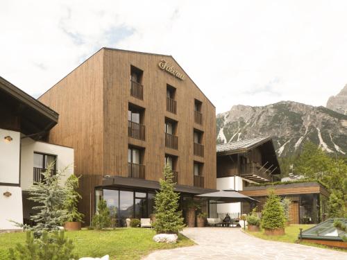 a large building with a view of the mountains at Faloria Mountain Spa Resort in Cortina dʼAmpezzo