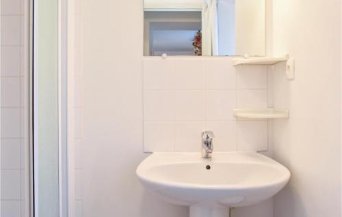 een witte badkamer met een wastafel en een spiegel bij Nice Home In Deux-jumeaux With 2 Bedrooms in Deux-Jumeaux