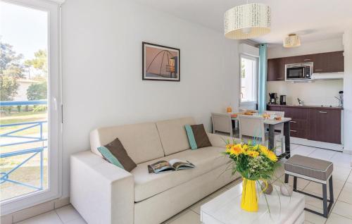 un salon avec un canapé et une table avec des fleurs dans l'établissement Les Carrelets, à Puyraveau