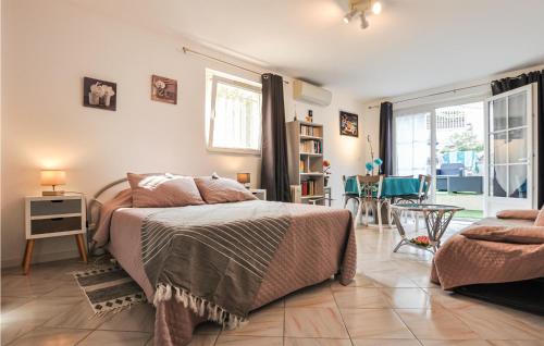 フレジュスにあるStunning Apartment In Frejus With Kitchenetteのベッドルーム1室(ベッド1台付)、リビングルームが備わります。