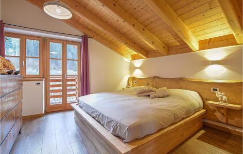 een slaapkamer met een bed in een kamer met houten plafonds bij 2 Bedroom Beautiful Home In Terzolas in Terzolas
