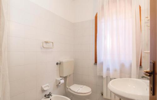 een witte badkamer met een toilet en een wastafel bij Marina 3 in Lido di Spina