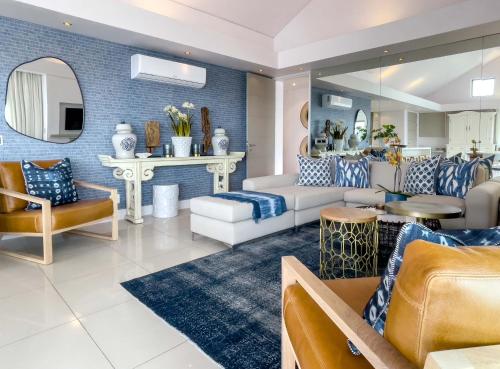a living room with blue and white furniture at Le Paradis Penthouse in Hermanus