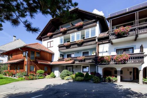 a large white building with flower boxes on the balconies at Apartments Wandaler am Kreischberg in Sankt Georgen ob Murau
