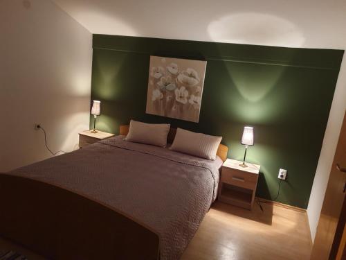 um quarto com uma cama grande e paredes verdes em Emi2 em Vir