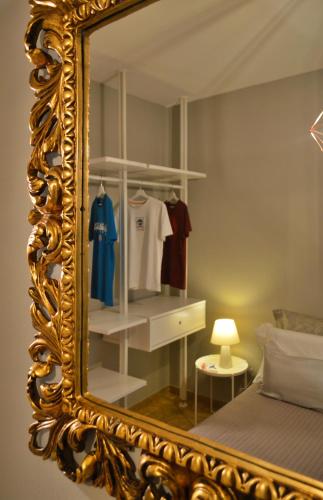 an ornate mirror in a bedroom with a bed at Omodarme52 in Pisa