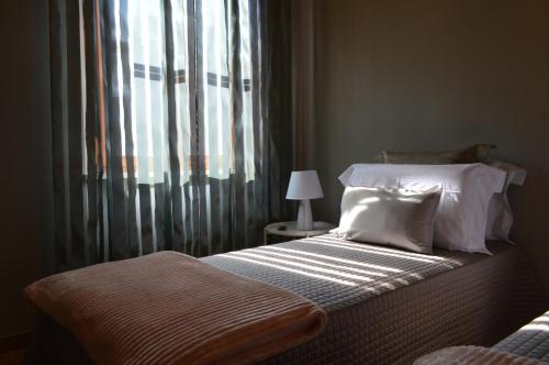 a bedroom with a bed and a window with curtains at Omodarme52 in Pisa