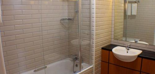 a bathroom with a tub and a sink and a shower at Downings Bay Hotel in Downings